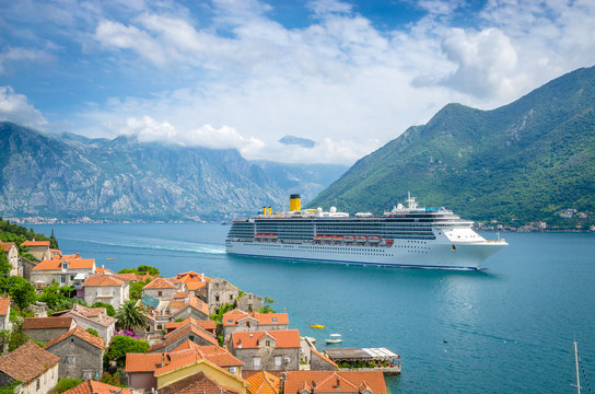A yacht sailing in the clear blue Mediterranean Sea near coastal cliffs
